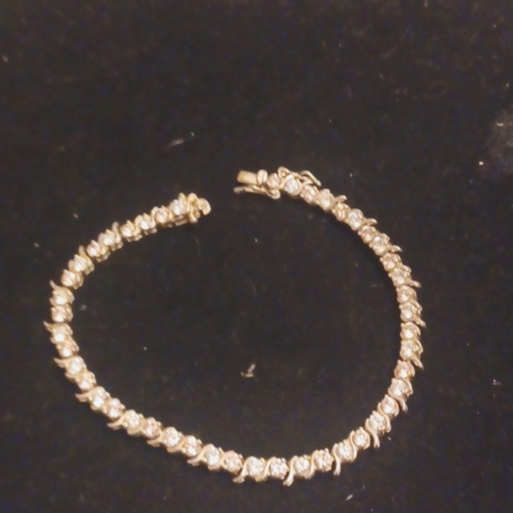 Solid sterling silver tennis bracelet with clear and very light pink stones.